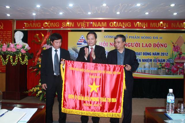 Đồng chí Lê Văn Châu - Phó Bí thư Đảng bộ, Tổng Giám đốc Tổng Công ty Sông Đà trao cờ Đơn vị dẫn đầu phong trào thi đua năm 2012 của Thủ Chính phủ